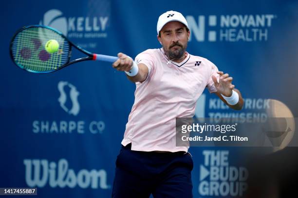 Steve Johnson of United States returns a shot to Pedro Martinez of Spain during their second round match on day four of the Winston-Salem Open at...