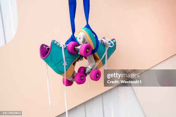 roller skates hanging in front of wall - roller en ligne photos et images de collection