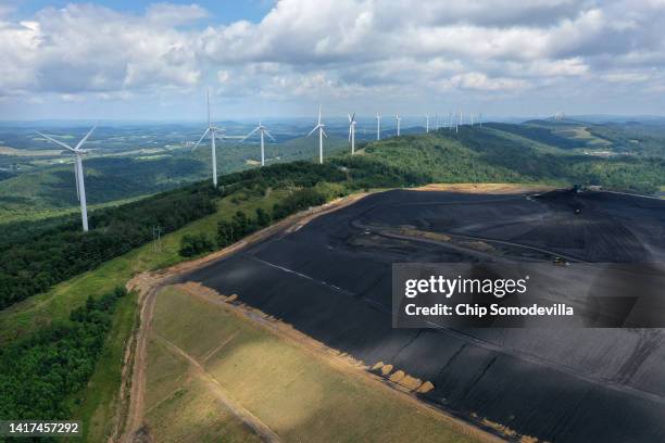In an aerial view, turbines from the Roth Rock wind farm spin on the spine of Backbone Mountain next to the Mettiki Coal processing plant on August...