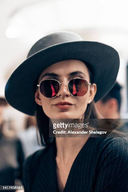 female portrait of beautiful woman who working fashion model at the fashion week show. backstage photography, behind the scenes of new clothing collection. girl wear eyeglasses and hat. - photo shoot makeup stock pictures, royalty-free photos & images