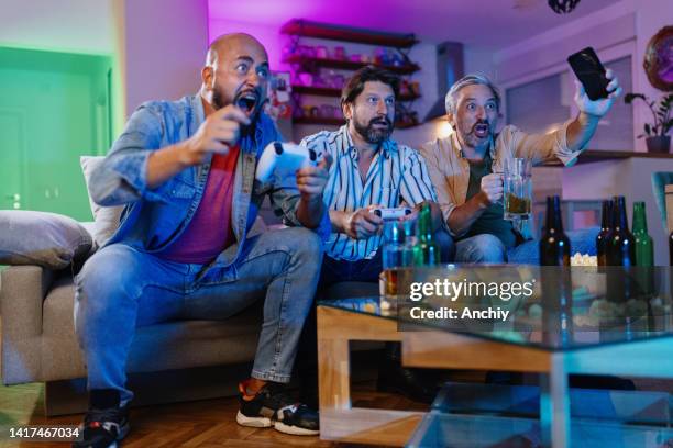 friends in competition playing games console - man cave stock pictures, royalty-free photos & images