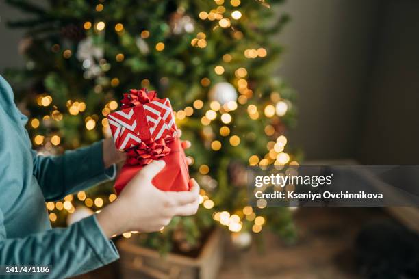 hands holding little gift with red bow. close up. - tavolo top view foto e immagini stock