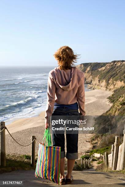 woman on stairs leading to a beach - beach bag overhead stock pictures, royalty-free photos & images