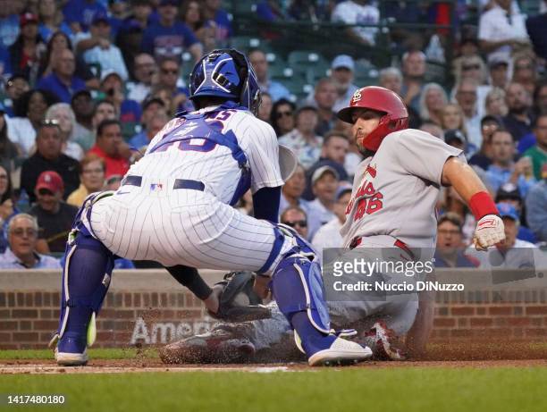 Paul Goldschmidt of the St. Louis Cardinals is tagged out at home by P.J. Higgins of the Chicago Cubs during the first inning of Game Two of a...