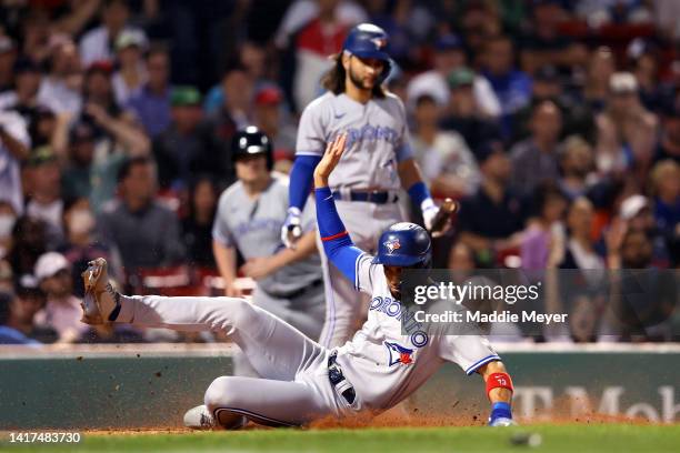 Lourdes Gurriel Jr. #13 of the Toronto Blue Jays slides into home to score against the Boston Red Sox during the third inning at Fenway Park on...