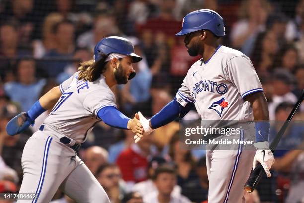 Bo Bichette of the Toronto Blue Jays celebrates with Jackie Bradley Jr. #25 after scoring a run against the Boston Red Sox during the third inning at...