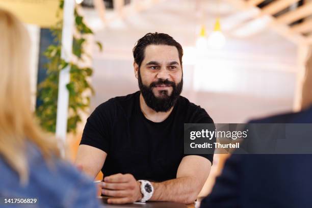 aboriginal australian man leading casual group meeting - tribe stockfoto's en -beelden