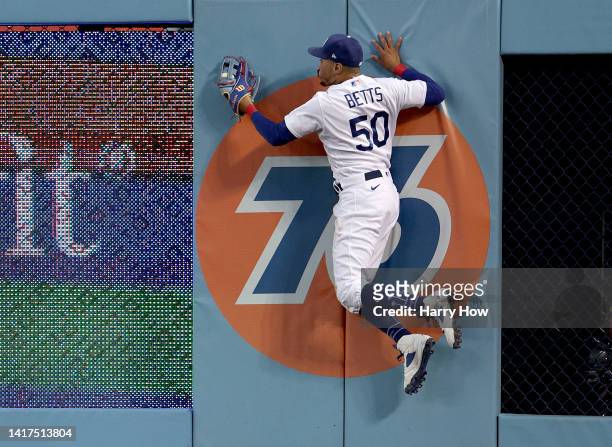 Mookie Betts of the Los Angeles Dodgers makes a catch for an out of Luis Urias of the Milwaukee Brewers to end the second inning at Dodger Stadium on...