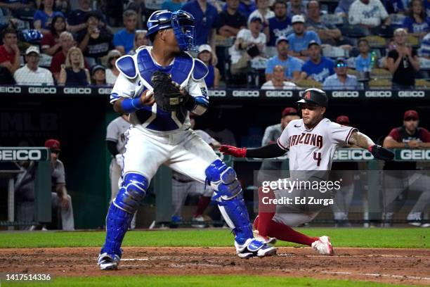 Ketel Marte of the Arizona Diamondbacks slides into home plate to score past Salvador Perez of the Kansas City Royals on a Jake McCarthy sacrifice...