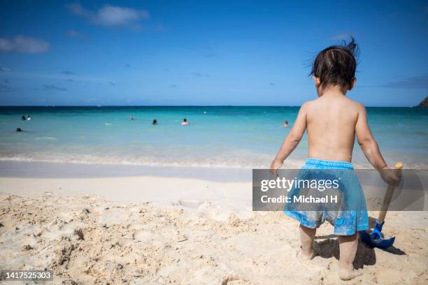 little boy playing with sand on a hawaiian beach - ハワイ stock-fotos und bilder