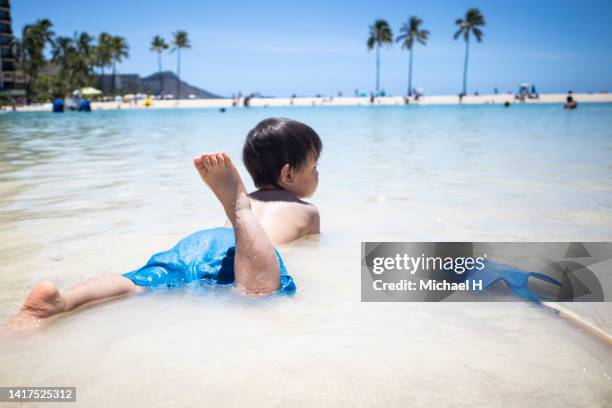 little asian boy playing in the ocean in hawaii. - ハワイ stock-fotos und bilder