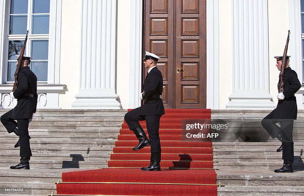 Three guards stand on the stairs of the