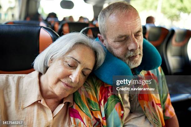 seniorenpaar beim nickerchen im reisebus - coach bus stock-fotos und bilder