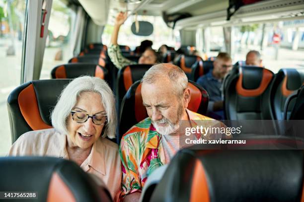 pensionierte touristen in den 60er und 70er jahren an bord von reisebussen - fahrzeug innenansicht stock-fotos und bilder