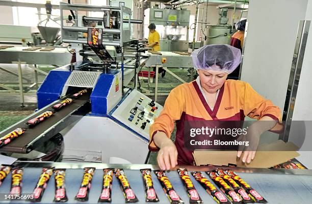 An employee packages Nestle SA king-size "Lion" chocolate bars as they travel along the production line at the company's Svitoch factory in Lviv,...