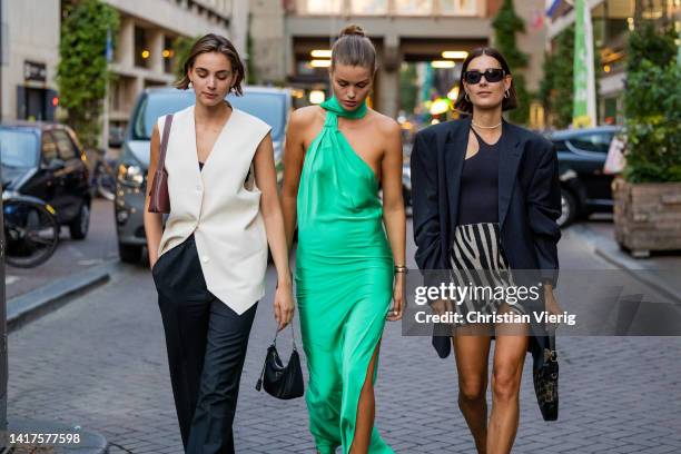Models Romy Schonberger wearing white vest, brown bag, black pants & Luna Bijl wearing green dress & Vera van Erp wearing zebra print shorts, navy...