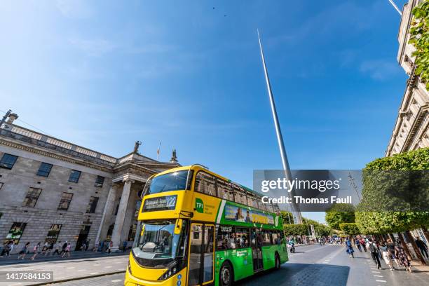 bus passes the spire in dublin - dublin bus stock pictures, royalty-free photos & images