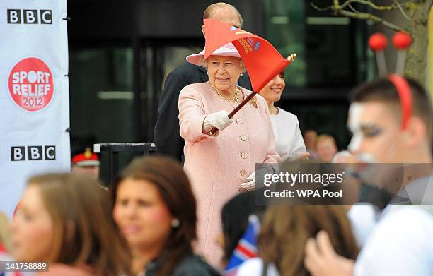 Queen Elizabeth II waves the flag to officially start the Sport Relief 2012 fun run in Salford, on March 23, 2012 in Greater Manchester, north-west...