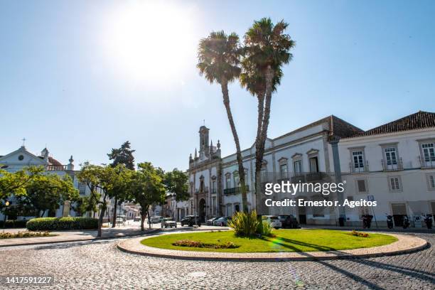 traffic circle with palm trees near  arco da vila, faro, portugal - faro city portugal foto e immagini stock