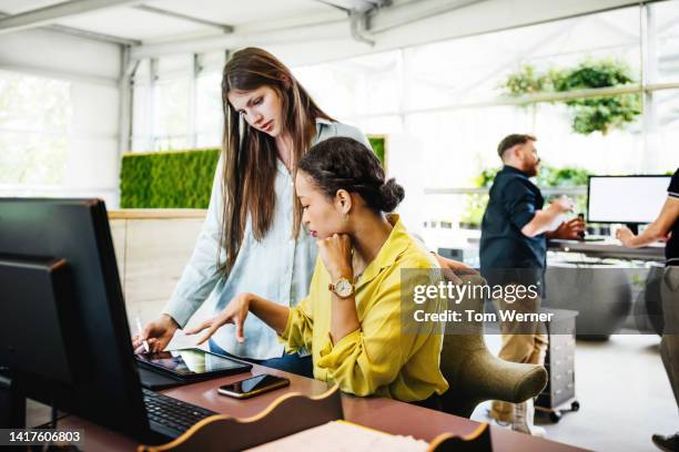 a modern office space with employees working at desks - intuitive stock-fotos und bilder