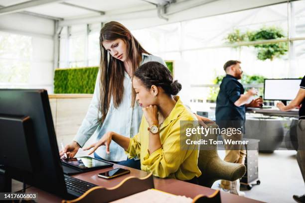 a modern office space with employees working at desks - business green color stock pictures, royalty-free photos & images