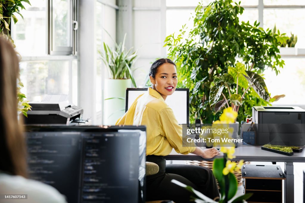 Woman Turning Head While Sitting At Computer Desk