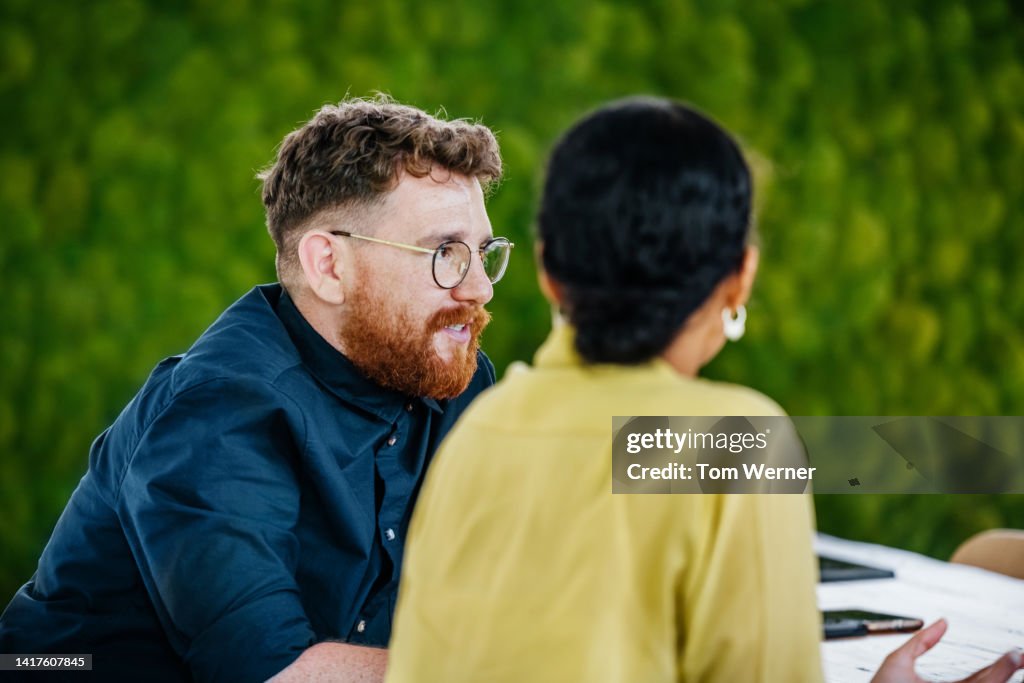 Two Office Colleagues Listening During Business Meeting