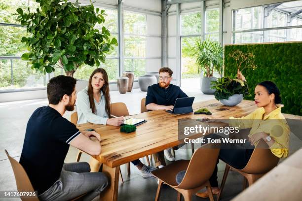 business team sitting at conference table for meeting in modern, minimal office environment - open day 4 stockfoto's en -beelden