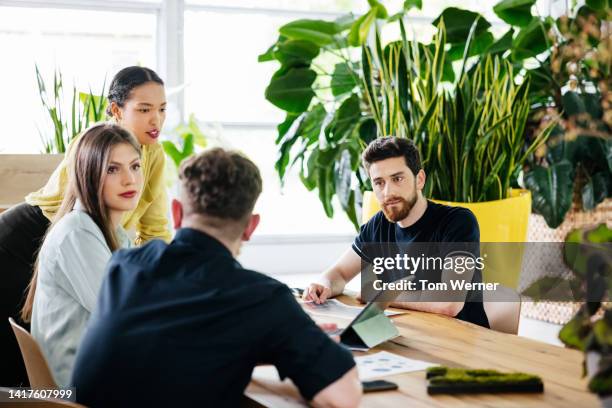 group of people in busy office meeting together - sunny office stock pictures, royalty-free photos & images