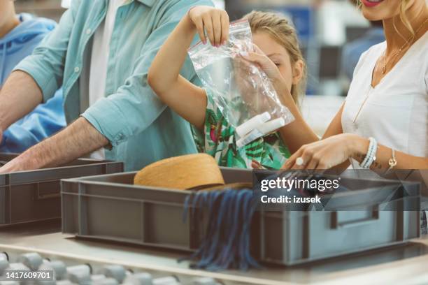 chica sosteniendo una bolsa de plástico en el control de seguridad del aeropuerto - security check fotografías e imágenes de stock