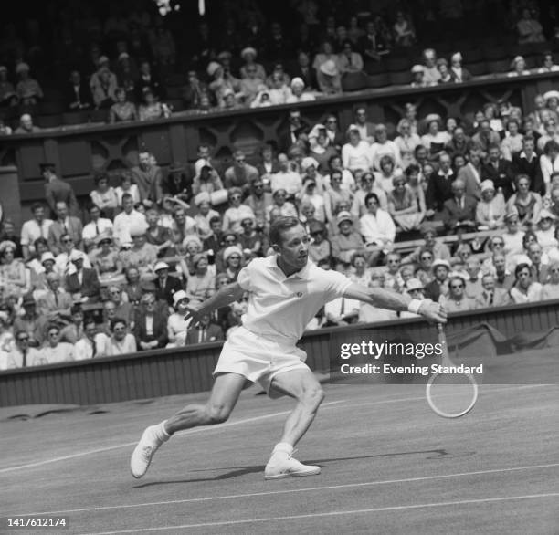 Australian tennis player Rod Laver stoops to return a shot during his third round match of the Men's Singles competition at the 1962 Wimbledon...