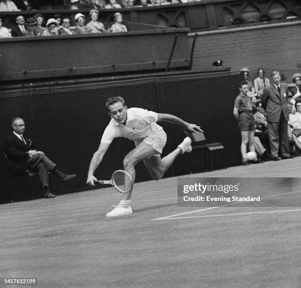 American tennis player Whitney Reed stoops to return a shot during his third round match of the Men's Singles competition at the 1962 Wimbledon...