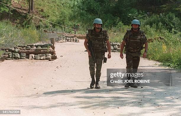 French UN soldiers pass through a passage protected by sand bags at Brezovaca on the Mount Igman, some 20 kms from Sarajevo, 17 July 1995. This zone...