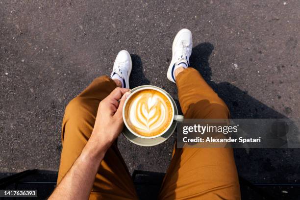 man drinking latte outdoors, personal perspective point of view (pov) - enjoying coffee cafe morning light stock-fotos und bilder