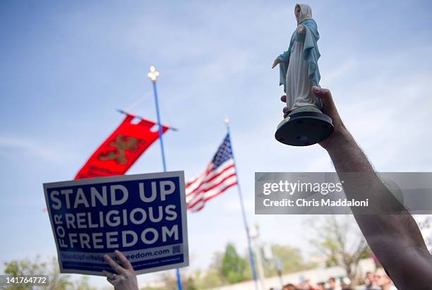 Demonstrator waves a Virgin Mary statue at a "Stand Up For Religious Freedom" rally, in support of "religious freedom" and opposition to health care...