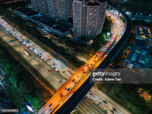 highway heavy traffic at night drone point of view with monorail bridge - malaysian road stock pictures, royalty-free photos & images