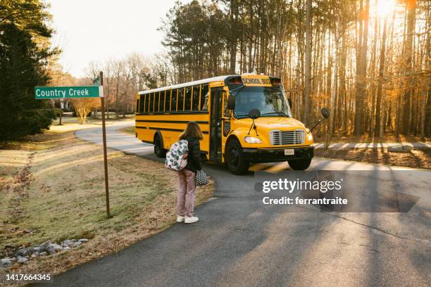 un élève du premier cycle du secondaire attend à l’arrêt d’autobus scolaire - bus scolaire photos et images de collection