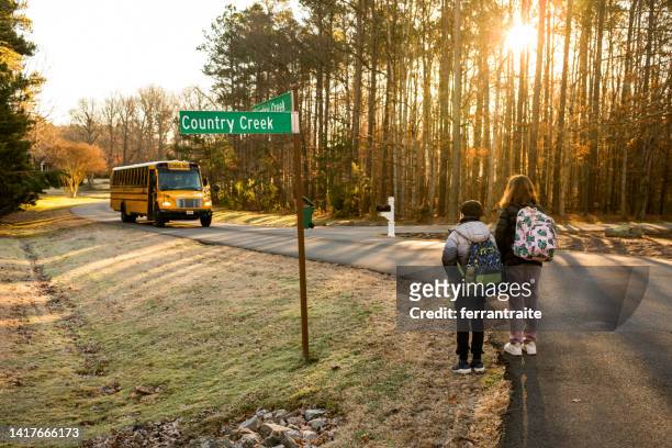 gli studenti delle scuole medie aspettano alla fermata dello scuolabus - morning foto e immagini stock