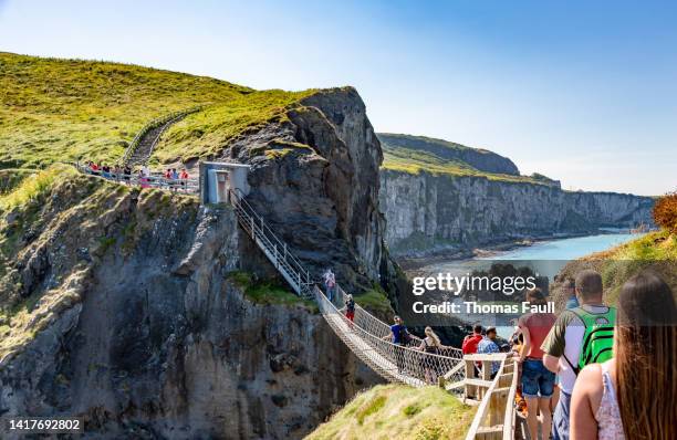 people queue for carrick-a-rede rope bridge - ireland coast line stock pictures, royalty-free photos & images