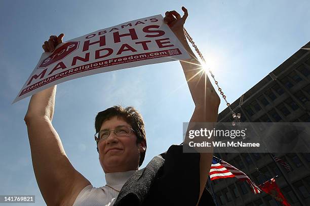 Elaine Drapeau holds a crucifix while joining protesters participating in a "Stand Up for Religious Freedom" rally in front of the Department of...