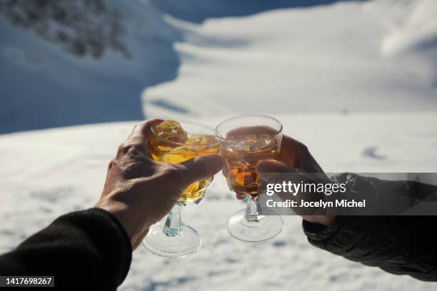 close up pov hands of friends toasting apres-ski cocktails in snow - after-ski foto e immagini stock