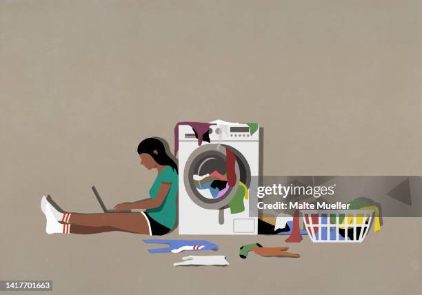 girl using laptop and doing laundry at clothes dryer - utility room stock illustrations