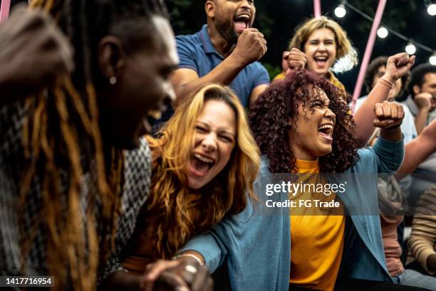 amigos assistindo a um jogo esportivo e celebrando ao ar livre - fã - fotografias e filmes do acervo