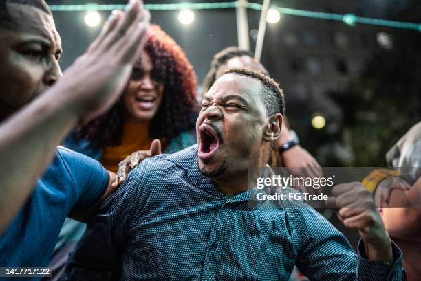amigos assistindo a um jogo esportivo e celebrando ao ar livre - fã - fotografias e filmes do acervo