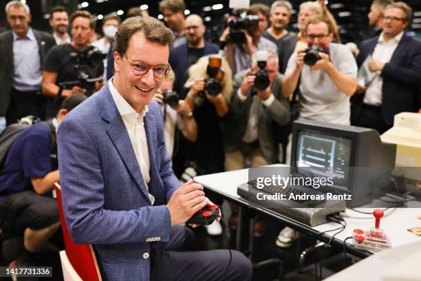 Hendrik Wüst, CDU premier of North Rhine-Westphalia uses a joystick on a Commodore 64 computer game during the press day at the 2022 Gamescom gaming...