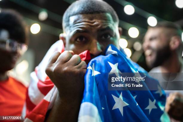 mid adult man kissing american flag outdoors - cu fan stock pictures, royalty-free photos & images