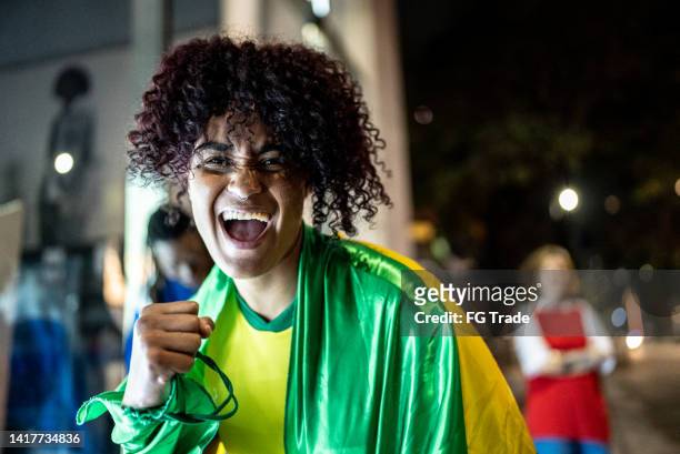 portrait of a brazilian soccer fan outdoors at night - female fans brazil stock pictures, royalty-free photos & images
