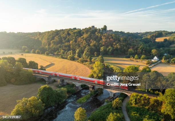 commuter train crossing a bridge - germann stock pictures, royalty-free photos & images