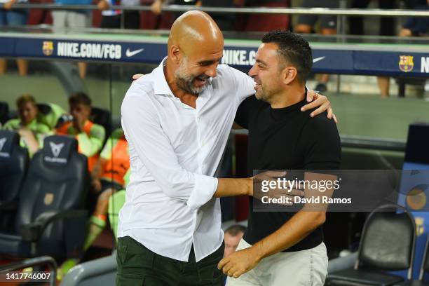 Pep Guardiola, Manager of Manchester City and Xavi, Head coach of FC Barcelona embrace prior to the friendly match between FC Barcelona and...