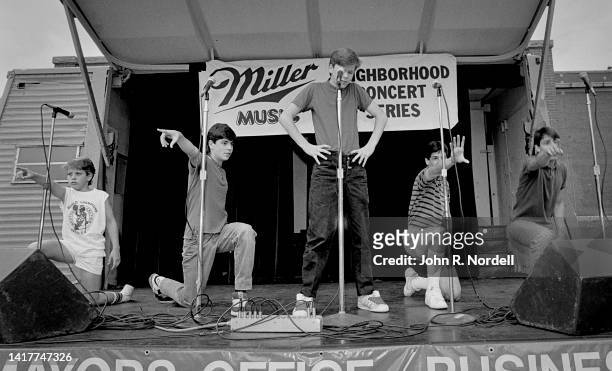 View of members of the American vocal pop group New Kids on the Block perform on stage as part of the 'Miller Lunchtime Concert Series,' Boston,...